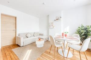 ein Wohnzimmer mit Tisch und Couch in der Unterkunft L'Eden - Porte de Paris - 10 min Stade de France in Saint-Denis