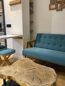 a blue couch and a table in a room at Tiny Nest - Sava Center, Belgrade in Belgrade