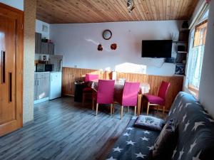 Una cocina y un comedor con una mesa y sillas rosas. en Apartmán Paula, en Liptovský Trnovec