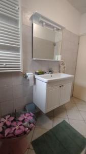 łazienka z białą umywalką i lustrem w obiekcie Apartmani Senka w mieście Ika +37 zdjęć