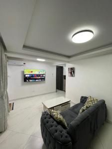 a living room with a couch and a tv at Infinity Villas 1 Superking bed Studio Apartment free parking , WiFi , 24 hr security in Entebbe