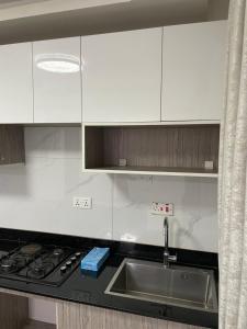 a kitchen with white cabinets and a sink at Infinity Villas 1 Superking bed Studio Apartment free parking , WiFi , 24 hr security in Entebbe