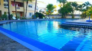 a large swimming pool with blue water in front of a building at Residence les orchidees D5 in Flic-en-Flac