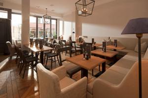 a restaurant with wooden tables and chairs and windows at Friedrich Inn in Norderney