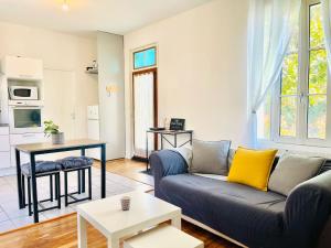 a living room with a couch and a table at Chez Arthur -Séjour en Sologne in La Ferté-Saint-Aubin