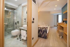 un bagno con lavandino e doccia e un letto di Downtown Sirkeci Hotel a Istanbul Altre 37 foto