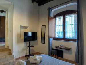 a bedroom with a bed and a tv and a window at La Nicchia in Cagliari