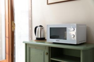 a microwave sitting on top of a table at Dimora Wilma in Peschiera del Garda