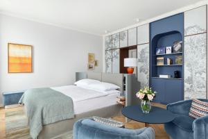 a bedroom with a bed and two chairs and a table at Hotel Angleterre in Lausanne +30 photos