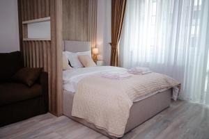 雅西Unirea Towers Deluxe Apartment Modern & Chic的一间卧室，床上有一张带毛巾的床