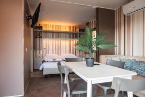 a room with a white table and chairs and a bed at Domvs Glamp in Baveno