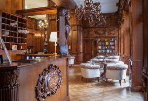 a dining room with tables and chairs and a chandelier at Boutique Hotel Gaia Superior in Kecskemét