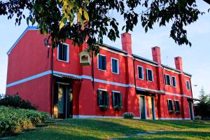 a red building with a white stripe on it at Agriturismo Monte Scala in Taglio di Po +15 photos