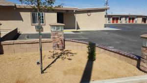 a fence with a street light in front of a building at Motel 6 Maple/Main in Hesperia