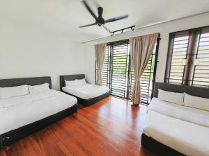a bedroom with two beds and a ceiling fan at 142 spacious 3storey 6BR 6bath for big family wedding birthday easy parking in Gelugor