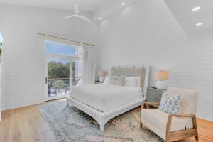 Un dormitorio blanco con una cama y una silla. en 5 Fishers Alley by Wild Dunes, en Isle of Palms 83 fotos más