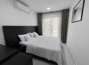 ein Schlafzimmer mit einem weißen Bett und einem Fenster in der Unterkunft The Divines Edge in Hikkaduwa