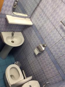 a small bathroom with a toilet and a sink at Residence la Flamboyance in Yaoundé +7 photos