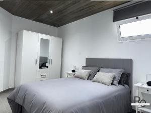 a white bedroom with a bed and a window at villa el rofero in Tinajo +14 photos