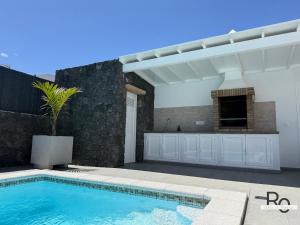 a swimming pool in front of a house at villa el rofero in Tinajo