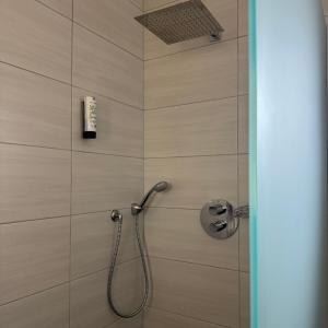 a bathroom with a shower with a phone on the wall at Weingut Tiliahof in Brauneberg +74 photos