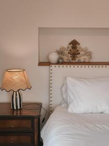 a bed with a lamp on a nightstand next to it at Quinta Amarela - B&B in Nazaré