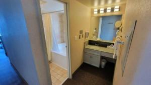 une salle de bain avec une baignoire, un lavabo et un miroir dans l'établissement Four Sails Resort, à Virginia Beach 8 autres photos