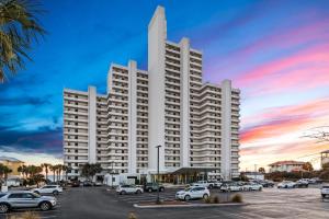 a large white building with cars parked in a parking lot at One Seagrove Place 0908 in Santa Rosa Beach
