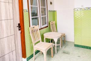 a table and chairs in a room with a window at Banyu Sri in Banyuwangi