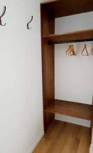 un angolo di una stanza con scaffali in legno con grucce di La porte Bleue - appartement juste rénové - très propre - grand confort - lumineux - calme - centre historique a Niort