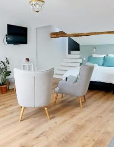 una camera da letto con un letto e due sedie di La porte Bleue - appartement juste rénové - très propre - grand confort - lumineux - calme - centre historique a Niort