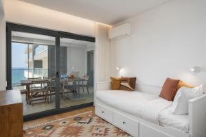 Un dormitorio con un sofá blanco y un comedor. en Acqua Residence VII - Luxury 3BR in Funchal, en Funchal 49 fotos más