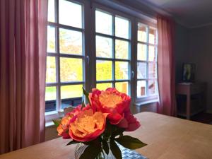 a vase of flowers on a table in front of a window at Haus Friesenfeuer in Nieblum