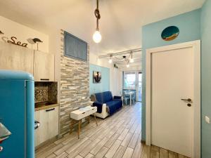 Una sala de estar con un sofá azul y una mesa. en TAMARICI BEACH HOUSE - Anzio, en Anzio