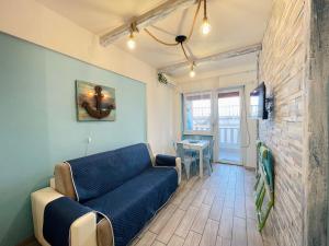 Una sala de estar con un sofá azul y una mesa. en TAMARICI BEACH HOUSE - Anzio, en Anzio