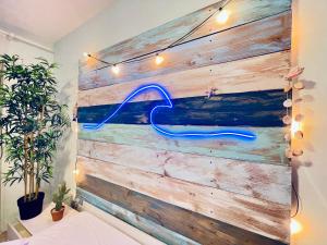 una pared de madera con una señal de neón azul. en TAMARICI BEACH HOUSE - Anzio, en Anzio