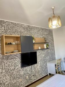 a room with a wall with a tv and a table at HORNEL Room in Padova +6 photos
