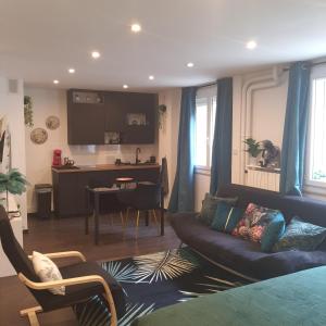 Una sala de estar con un sofá y una cocina. en Loft spacieux-2 min de la plage, en Marsella
