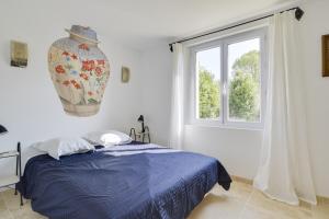 a bedroom with a blue bed and a window at Villa Cali - Air-conditioned, Pool, Heart Village in Cabrières-dʼAvignon