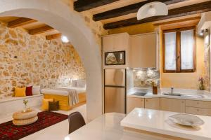 a kitchen with a table and a room with a bed at Giota's House in Chania Town