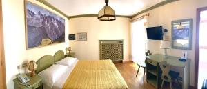 a bedroom with a bed and a desk and a bed and a table at Albergo Garnì Ajarnola in Auronzo di Cadore