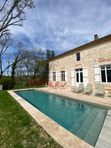 a swimming pool in front of a brick building at La Métairie La Maison de Ninette in Castelculier