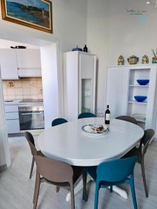 a white dining room table with chairs and a bottle of wine at Villa Lina in Castiglioncello