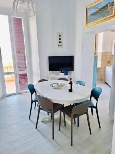 a dining room with a white table and chairs at Villa Lina in Castiglioncello +37 photos