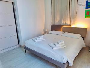 a bedroom with a white bed with towels on it at Villa Lina in Castiglioncello