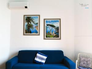 a blue couch in a living room with two pictures at Villa Lina in Castiglioncello
