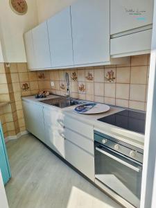 a kitchen with white cabinets and a sink at Villa Lina in Castiglioncello