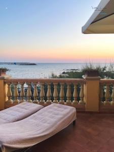 three beds on a balcony with a view of the ocean at Villa Lina in Castiglioncello