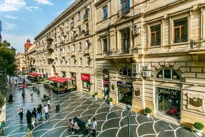 a group of people walking on a street in front of buildings at Apartment AERİA in Baku