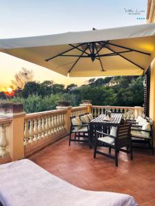 a patio with a table and chairs and an umbrella at Villa Lina in Castiglioncello